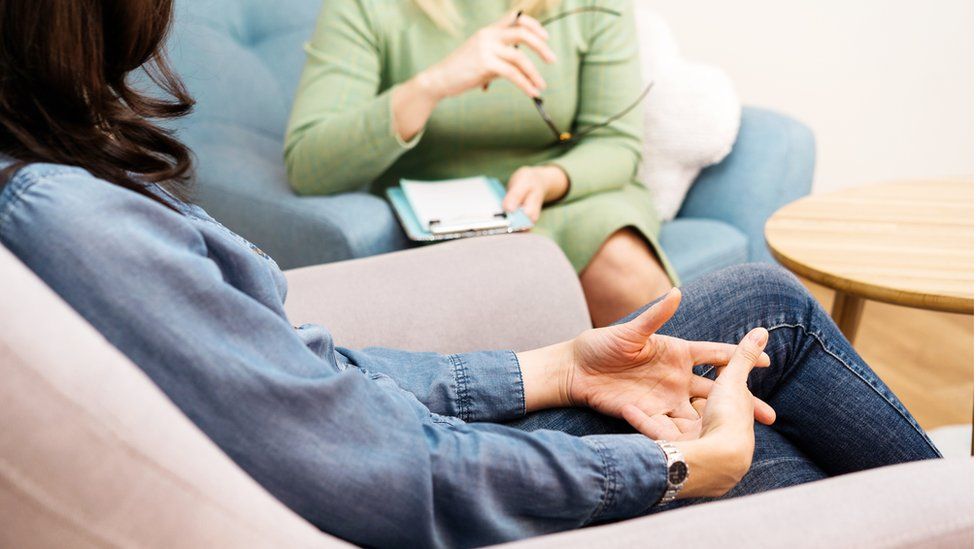 Psychiatrist talking to patient (model posed stock photo)