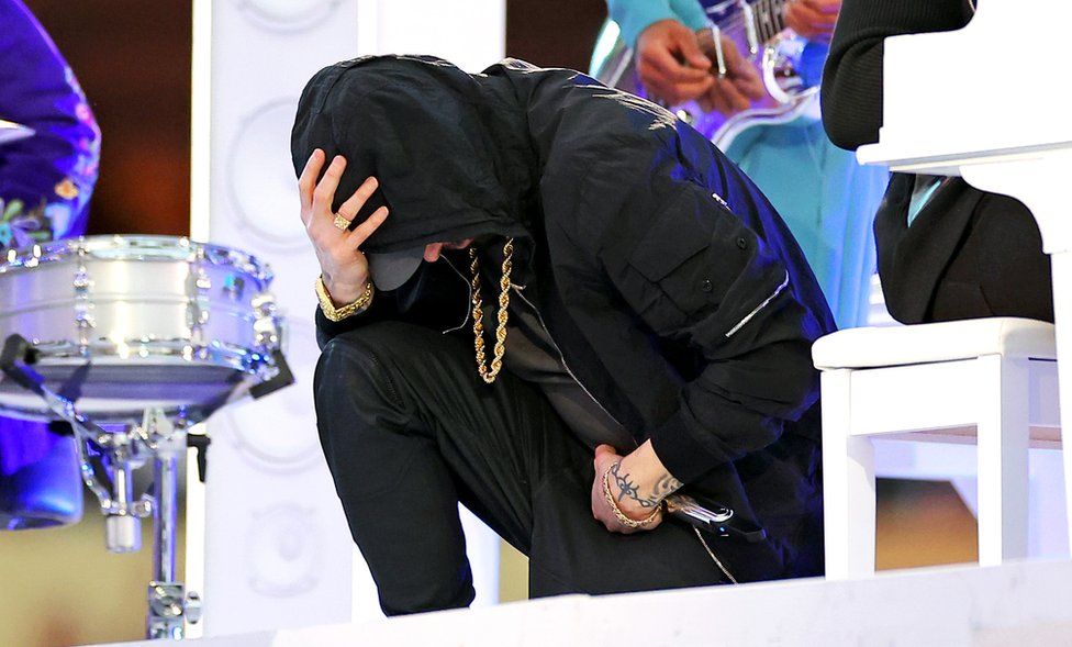 Eminem takes a knee as he performs during the halftime show