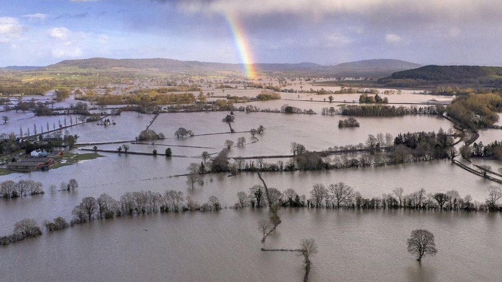 A rainbow appears over flooded fields in the Wye Valley, near the hamlet of Wellesley.