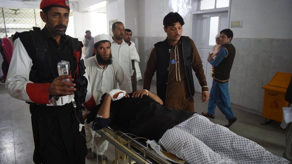 Pakistani medics move an injured security personnel for a treatment at a hospital in Peshawar on February 15, 2017