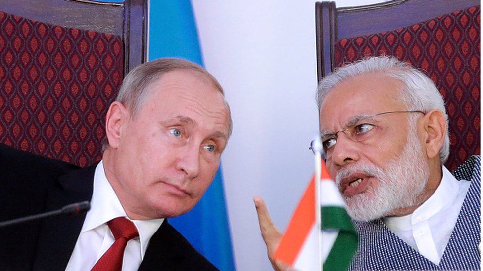 India Prime Minister Narendra Modi (R) gestures as he speaks with Russian President Vladimir Putin during the exchange of agreements and joint press statements ceremony at Taj Exotica hotel in Goa on October 15, 2016