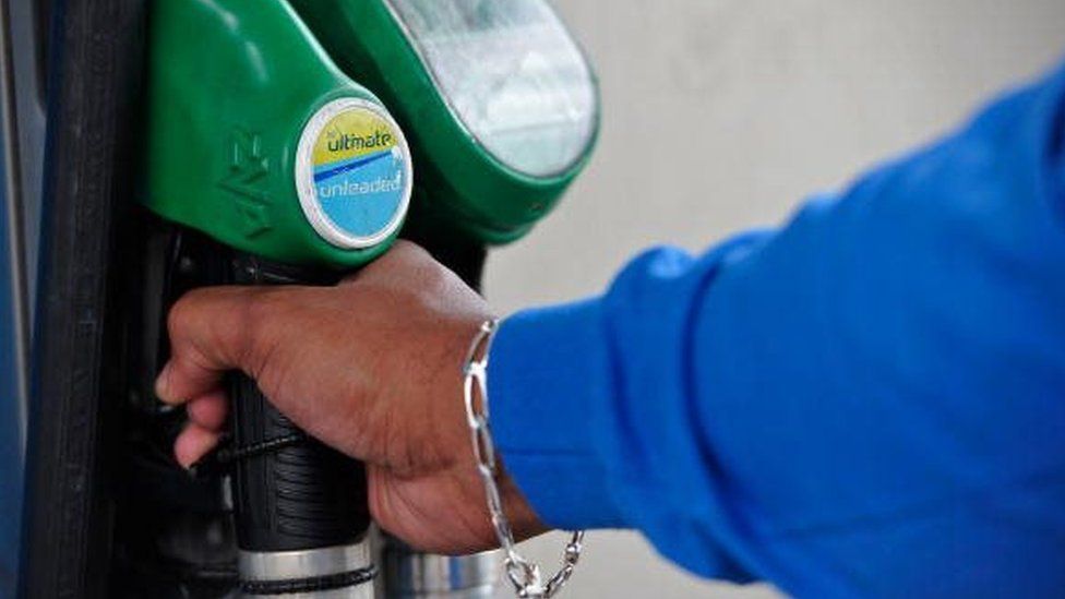 A person uses a petrol pump in a BP filing station in Peckham, south London