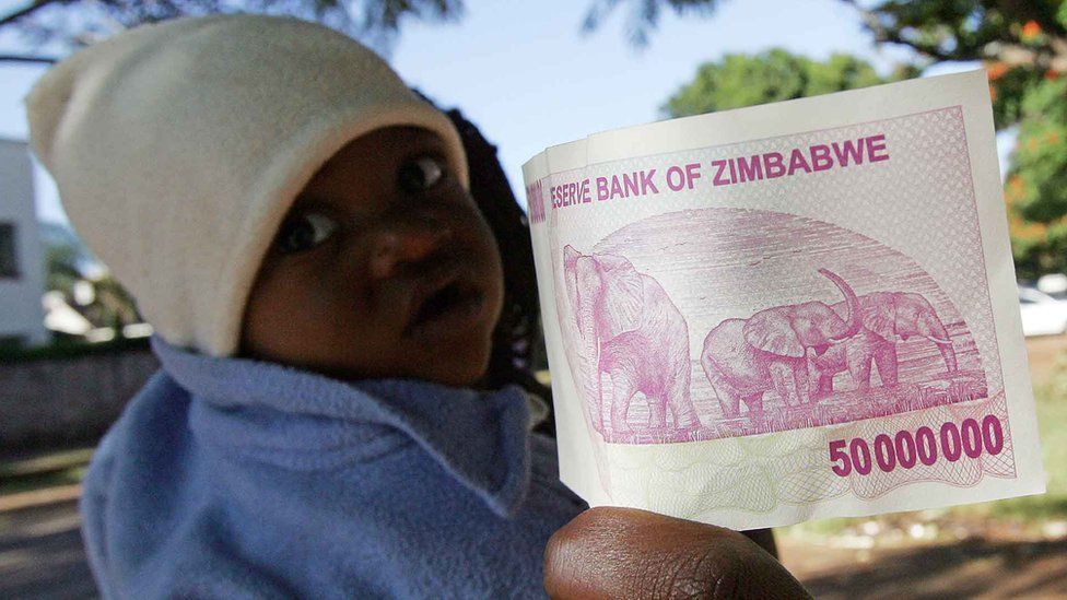 Zimbabwe's new fifty million dollar note, issued by the Reserve Bank on April 4, 2008, is pictured in Harare next to a toddler.