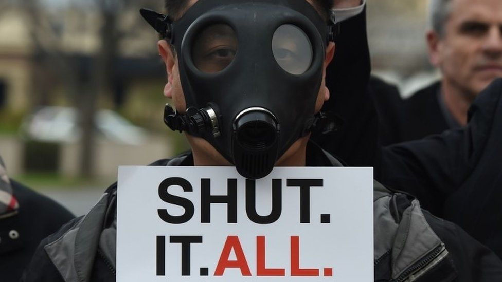 A Porter Ranch resident wearing a gas mask as he joins others in a protest outside a meeting of the Air Quality Management Board (23 January 2016)