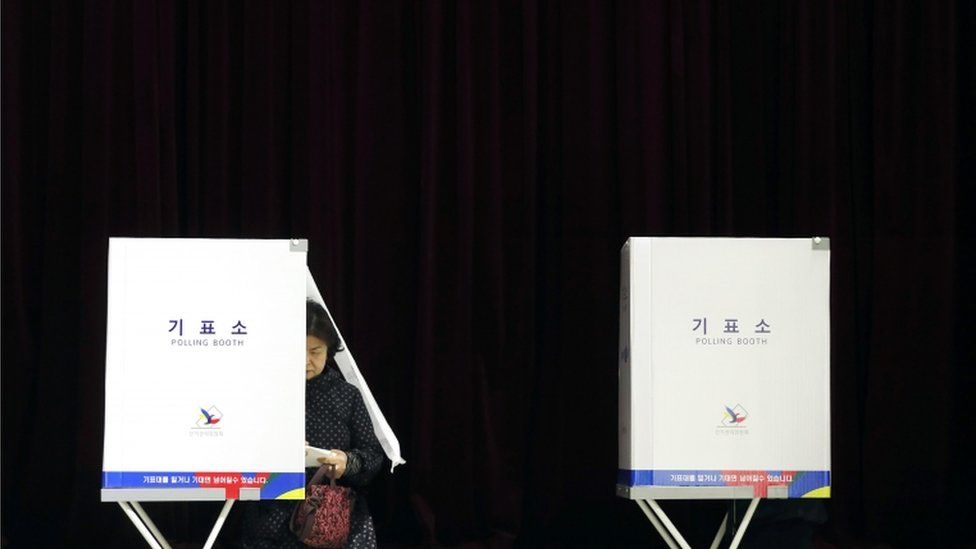 A South Korean woman casts her vote at a polling station in Seoul