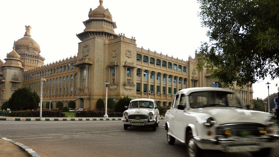 Government-owned Ambassador cars exit the state legislative assembly building in Bangalore (30 May 2014)