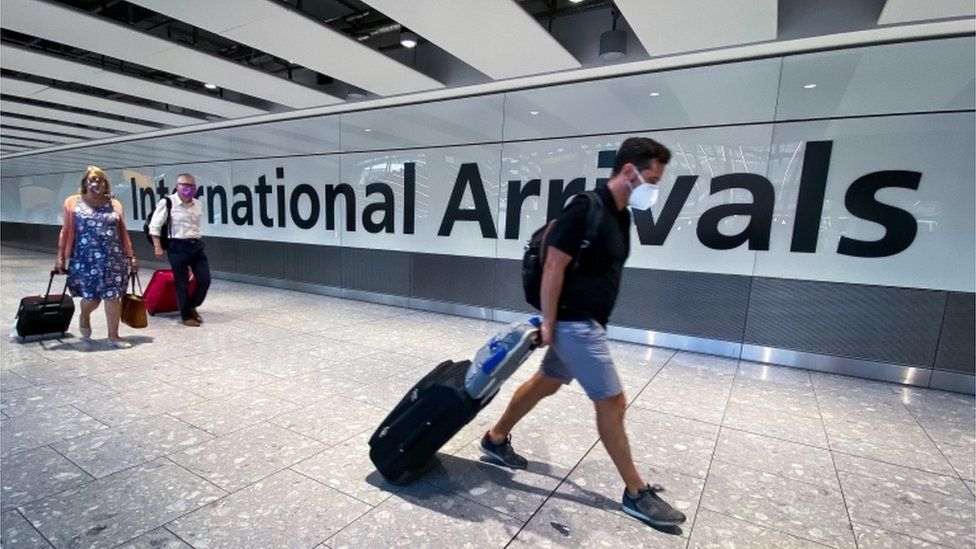 People arriving at Heathrow airport wearing face masks