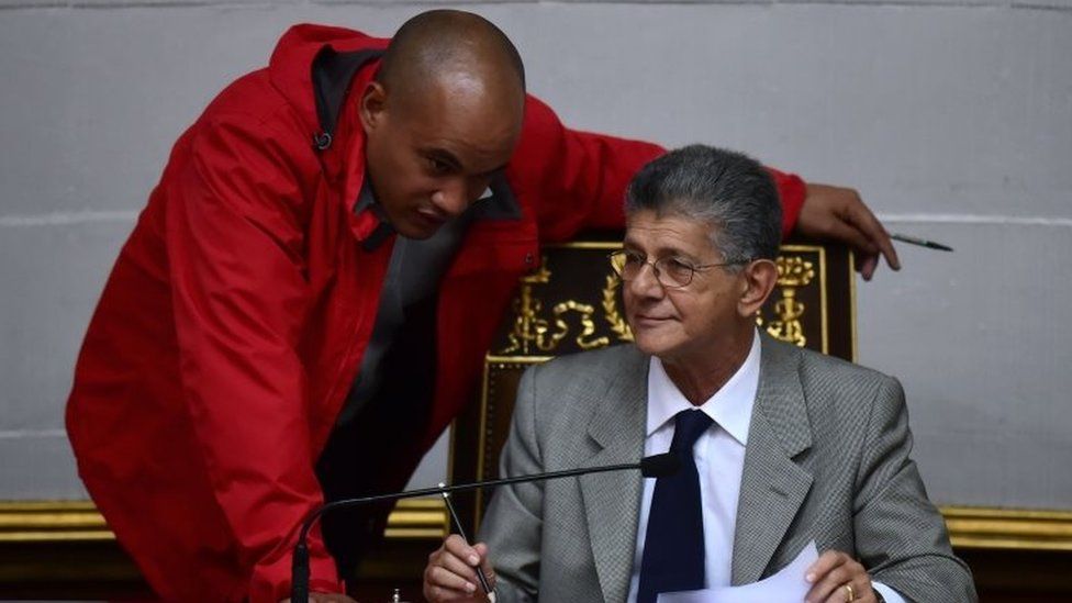 The president of the Venezuelan National Assembly, Henry Ramos Allup (R), listens to Venezuelan deputy Hector Rodriguez, chief of the pro-government legislative bloc, during a session of parliament in Caracas on November 1, 2016.