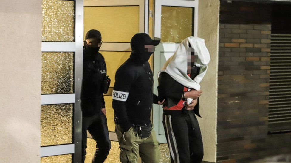 Police guide an arrested person out of a residential house in Hagen, western Germany, on 3 May 2023