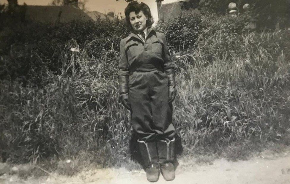 Black and white photo of Cpl Phyllis Bull in flying suit and sheepskin boots