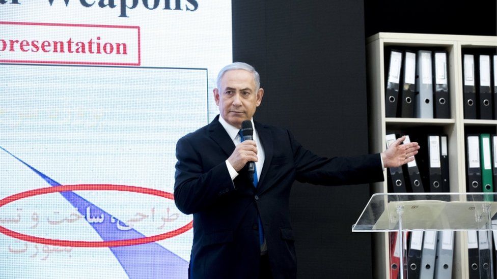 Israeli Prime Minister Benjamin Netanyahu on stage presenting documents allegedly stolen from Iran's nuclear archives