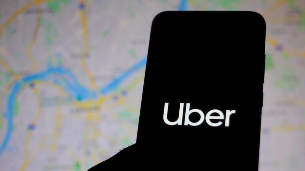 silhouette of phone with Uber logo, map background
