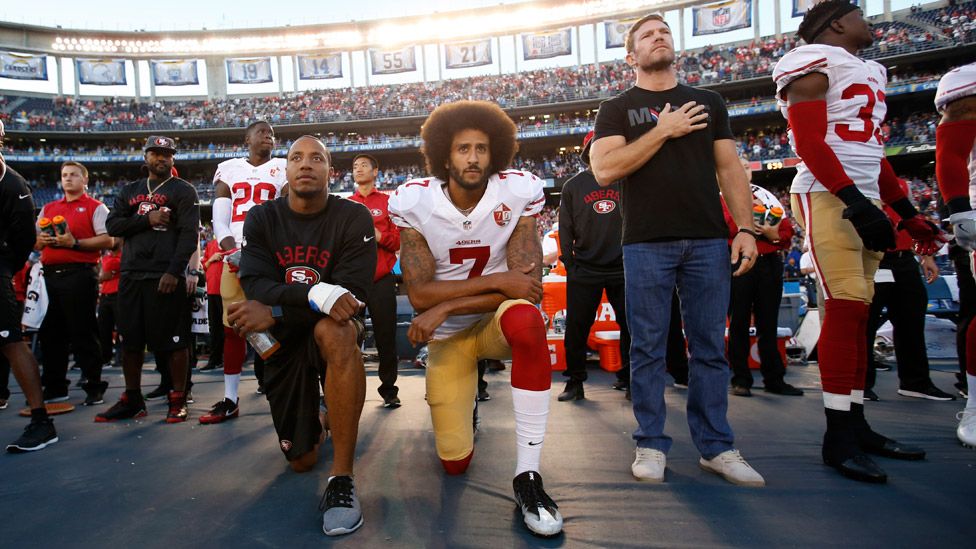 Colin Kaepernick (centre) and Eric Reid (left) taking the knee in San Diego in September 2016