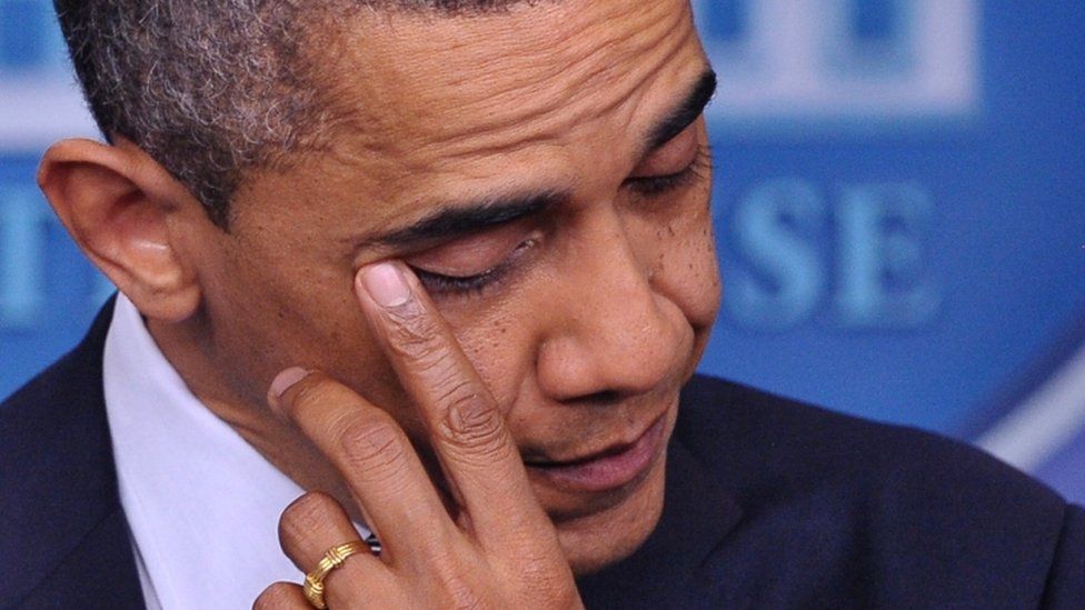 Former US President Barack Obama wipes his eye as he speaks during a previously unannounced appearance in the Brady Briefing Room of the White House on December 14, 2012 in Washington, DC