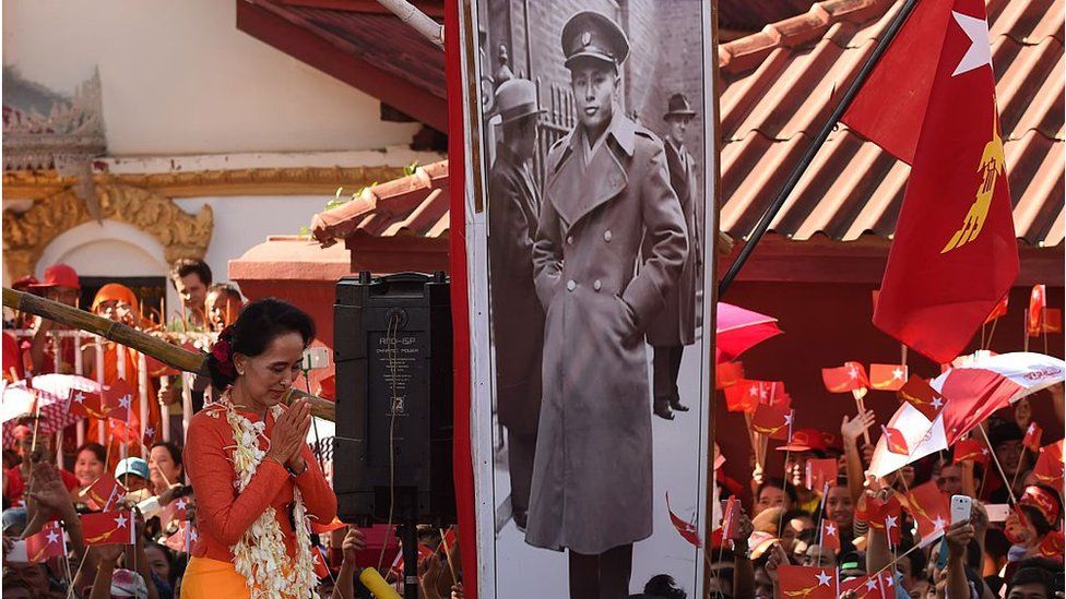 Лидер оппозиции Мьянмы Аунг Сан Су Чжи спускается со сцены, украшенной портретом ее покойного отца и героя независимости Мьянмы генерала Аунг Сана