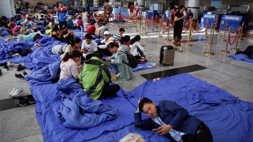 Stranded passengers rest at the departure hall of Jiuzhaigou airport near the remote, mountainous area struck by a deadly earthquake in Sichuan province