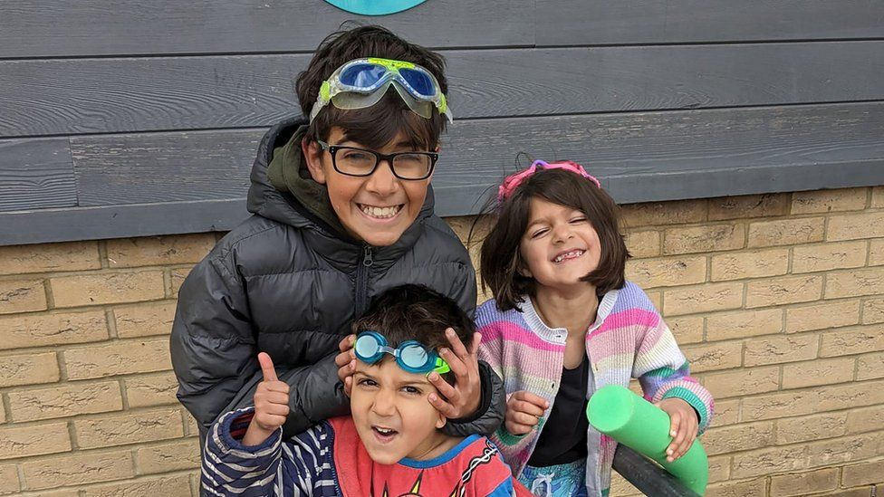 Kamran, Harris and Eve wearing swimming goggles outside their leisure centre.