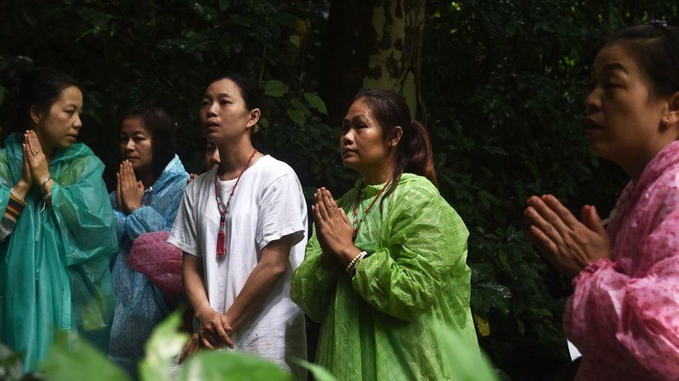 Relatives offer prayer near the Tham Luang cave