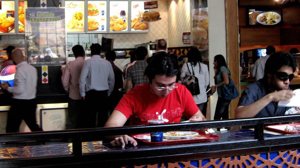 People eat at a fast food outlet in Dubai
