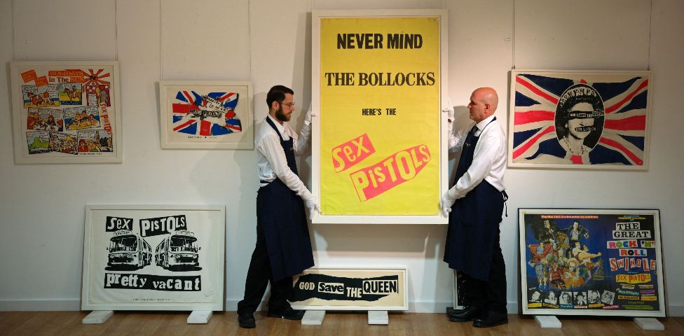 Gallery assistants put up a work from British artist, Jamie Reid, "Never Mind The Bollocks", a promotional poster for the release of the album, at a preview in London on October 12, 2022, part of the Stolper-Wilson Collection of Sex Pistols memorabilia, coming to auction at Sotheby's in London on October 21, 2022