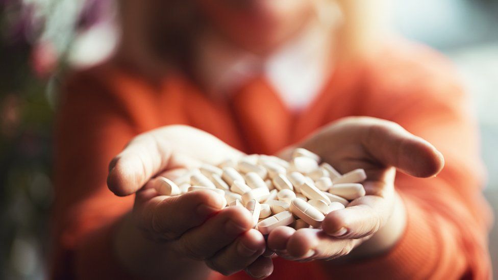 woman holding pills