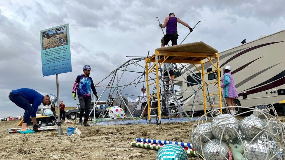 Burning Man attendees strike down their camp in the Nevada desert