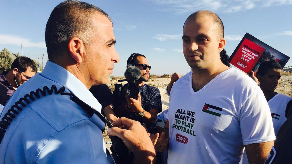 Palestinian protest organiser Fadi Quran speaks to Israeli soldiers near entrance to West Bank settlement of Maale Adumim (12 October 2016)