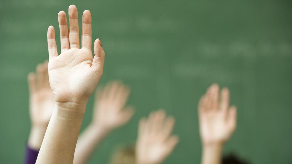 Hands raised in classroom