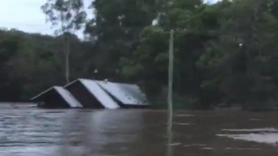 A house being swept away by floodwaters in Australia