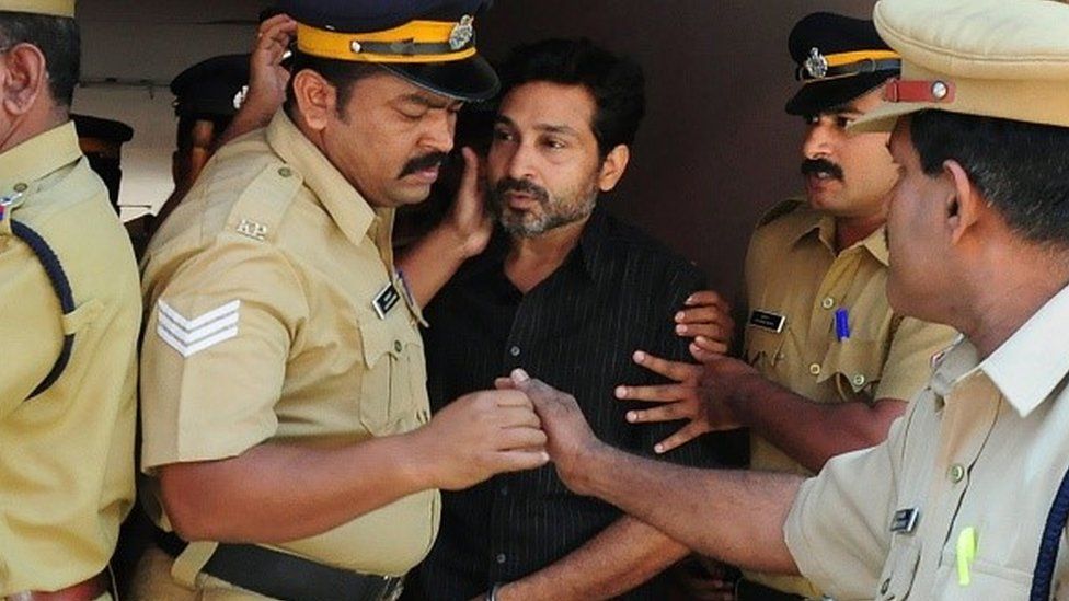 Indian police personnel escort murder suspect Muhammad Nisham (C), accused of fatally wounding a security guard by driving into him with his car, at the Judicial Magistrate's Court in Thrissur on March 11, 2015.