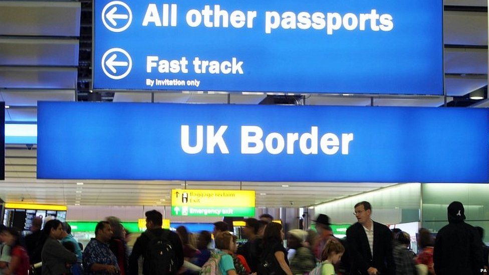Travellers queuing as passport control at Heathrow airport