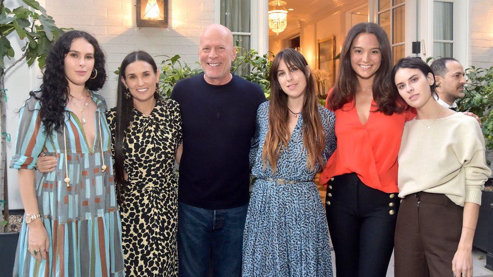 Willis celebrates the book launch of Demi Moore's memoir with their three daughters and his wife, Emma (second from right)