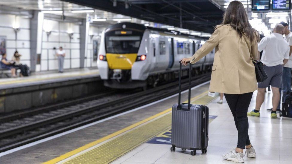 A woman waits for a train in London, August 2022