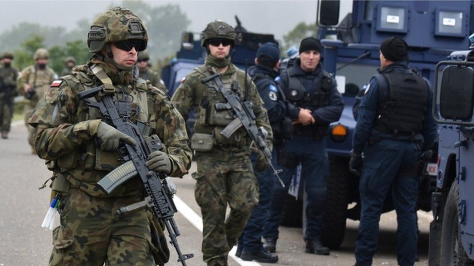 Members of the KFOR peacekeeping force patrol the area near the border crossing between Kosovo and Serbia in Jarinje, Kosovo, October 2, 2021