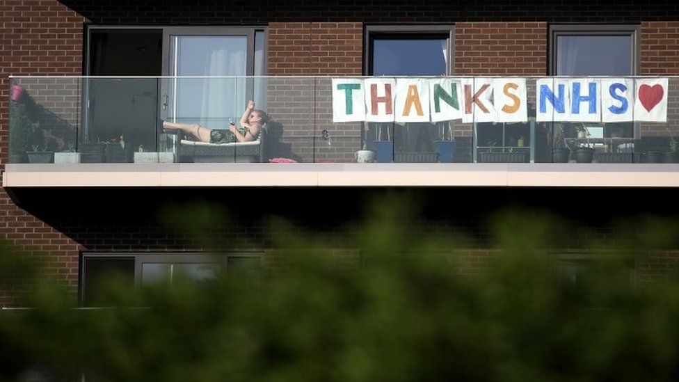 People living in a block of flats show a message hanging from their balcony thanking the NHS at Queen Elizabeth Olympic Park on April 11, 2020 in London,