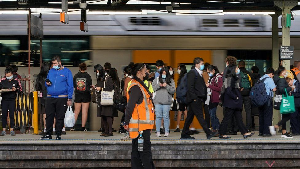 Commuters wear protective face masks on a train platform at Central Station in Sydney