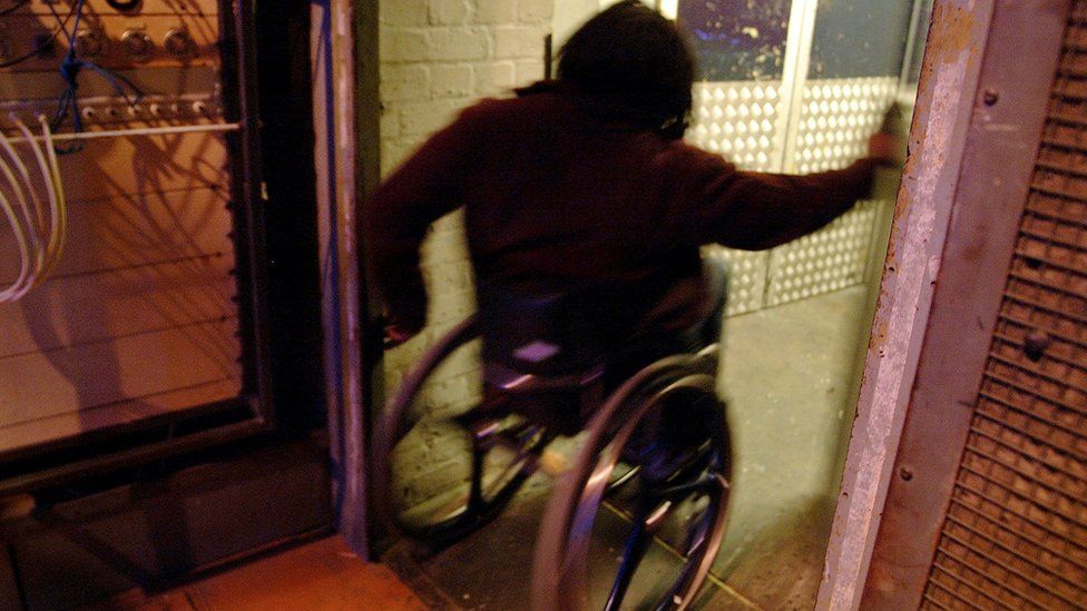 A man in a wheelchair going through a doorway