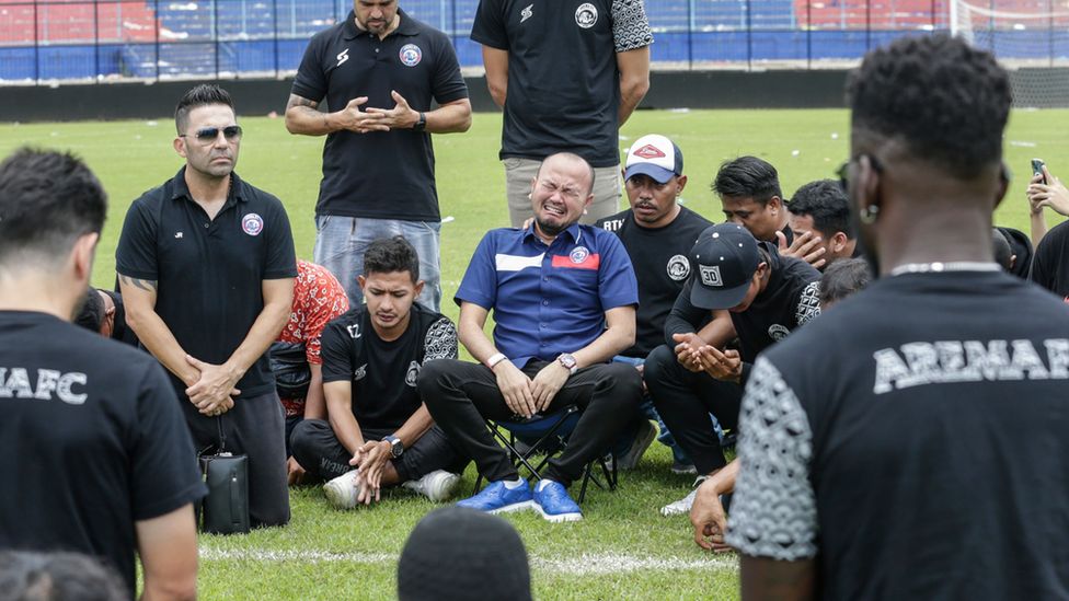 Players and officials of Arema FC mourn as they pay condolence to the victims of the soccer match riot and stampede on the pitch at Kanjuruhan Stadium in Malang, East Java,