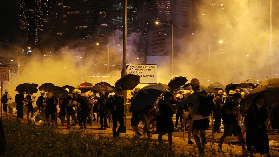 Protesters huddle as tear gas is fired