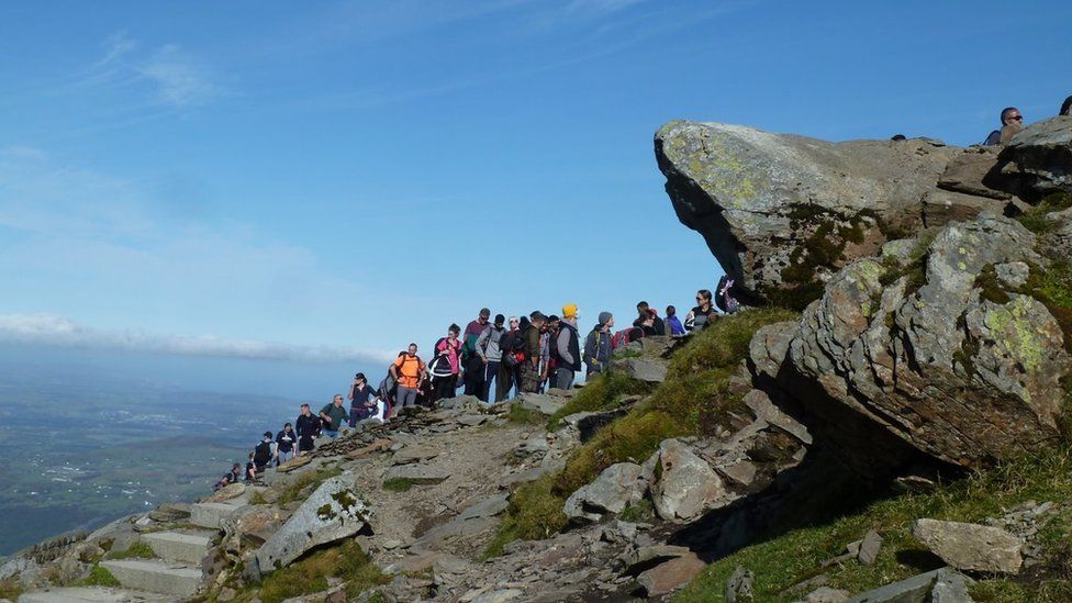 People queue to reach the trig point on the summit of Snowdon, September 27, 2020