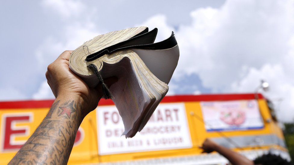 A demonstrator holds a bible at the Triple S convenience store where Alton Sterling was shot dead by police in Baton Rouge, Louisiana, U.S. July 9, 2016.