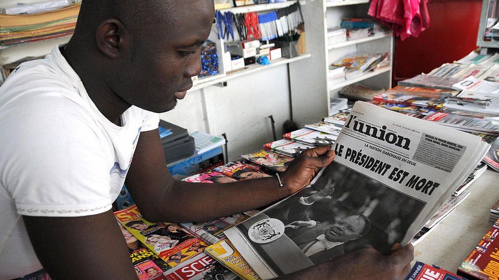 A young man reads a newspaper announcing the death of Gabon's President Omar Bongo Ondimba in a shop in Libreville on June 9, 2009.
