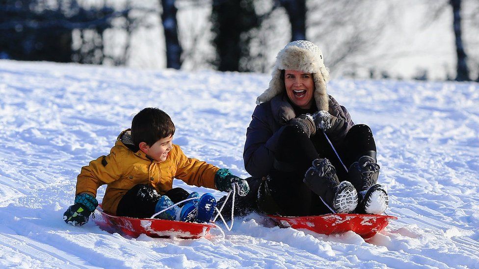 A woman sledging with her son on Camp Hill, Woolton
