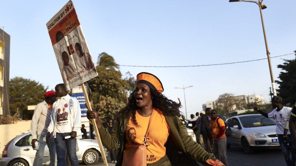 A supporter of Idrissa Seck holds a placard during a gathering in Dakar on February 19, 2019