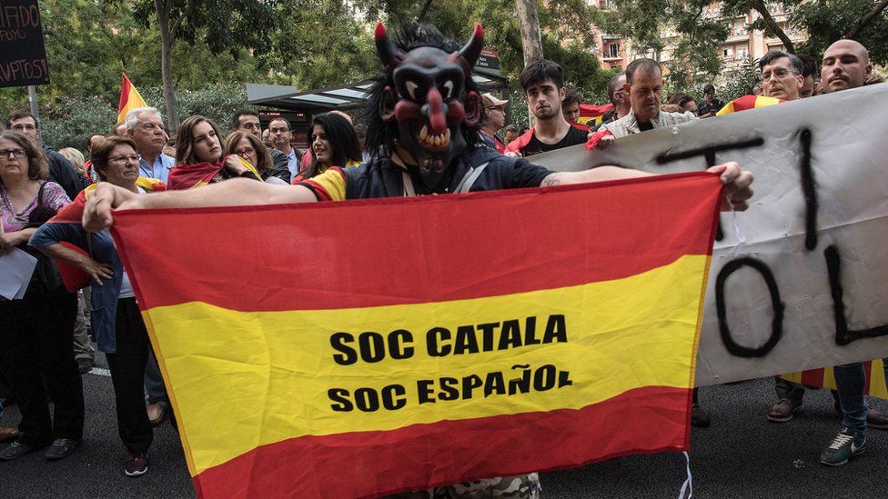 Man with flag saying "Soc Catalan/ Soc Espanol" at anti-separatist demonstration