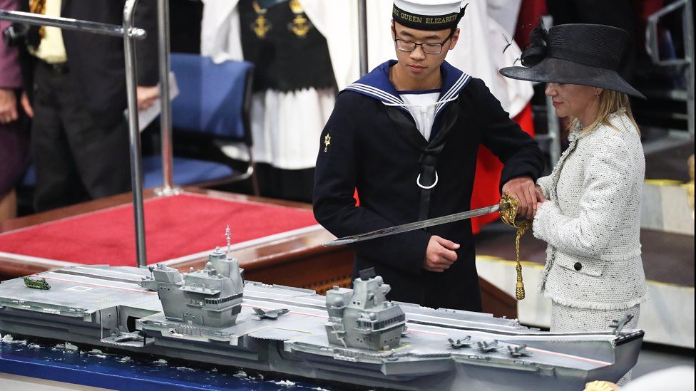 AB Callum Hui and Dr Karen Kyd cutting the cake at the commissioning of HMS Queen Elizabeth.