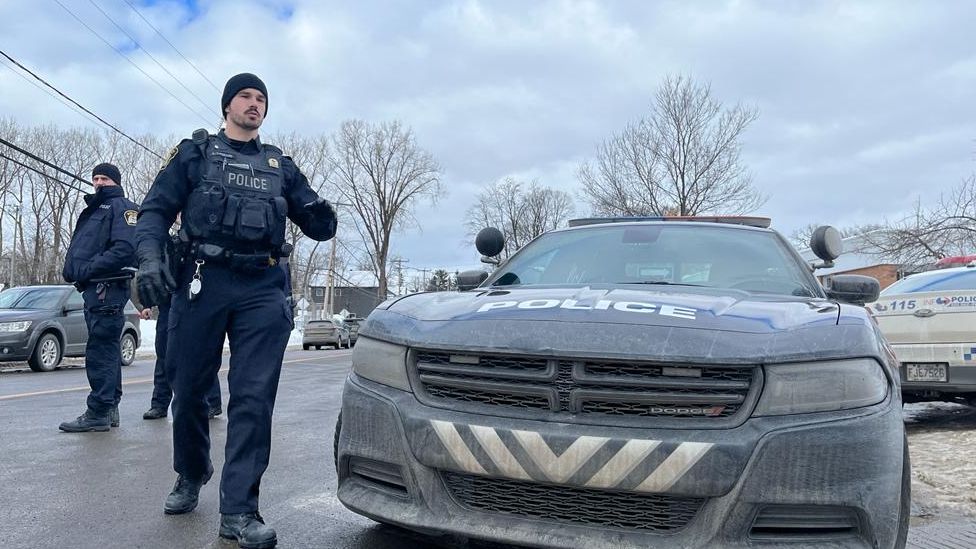 A police officer outside the crime scene in Laval, QC