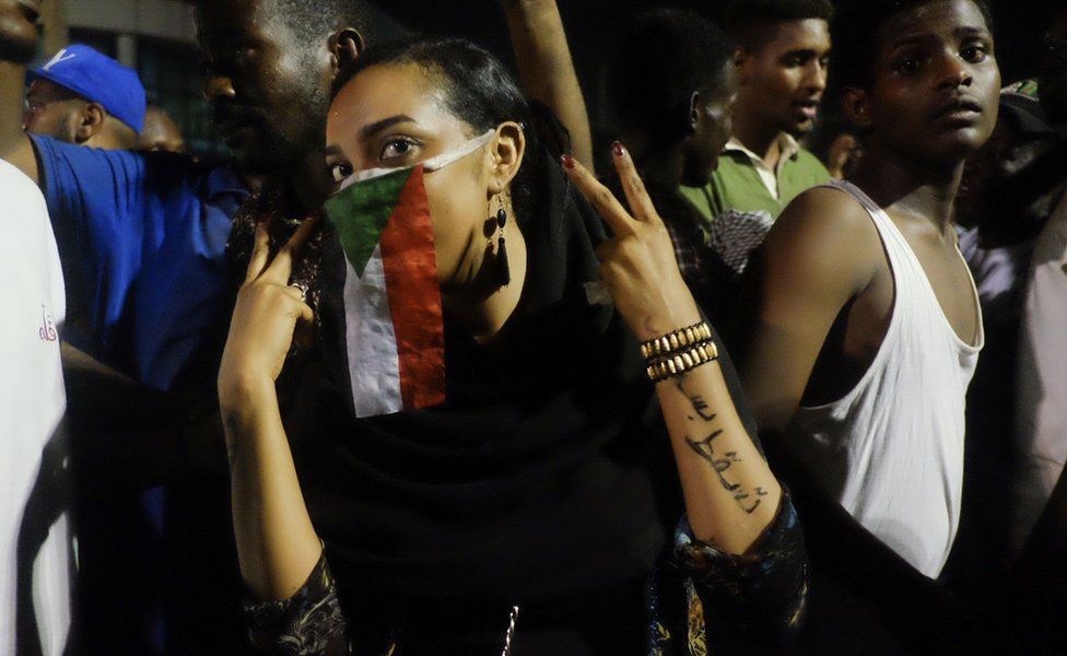 A woman with a Sudanese flag over her face at a sit-in at the military HQ in Khartoum, Sudan - Monday 8 April 2019