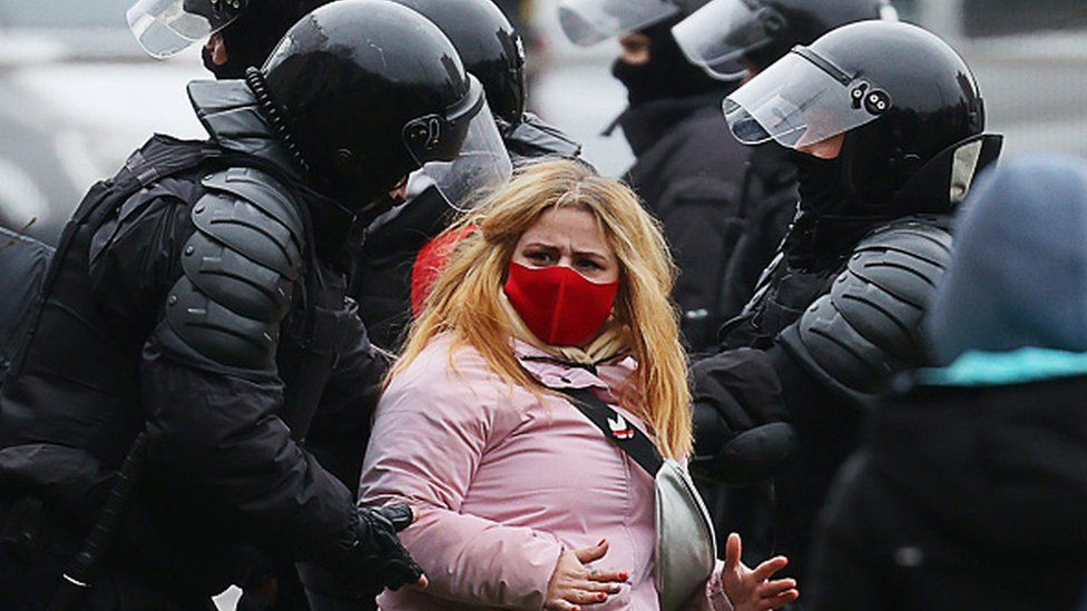 Law enforcement officers detain a female protester wearing a face mask in Minsk, 15 November 2020