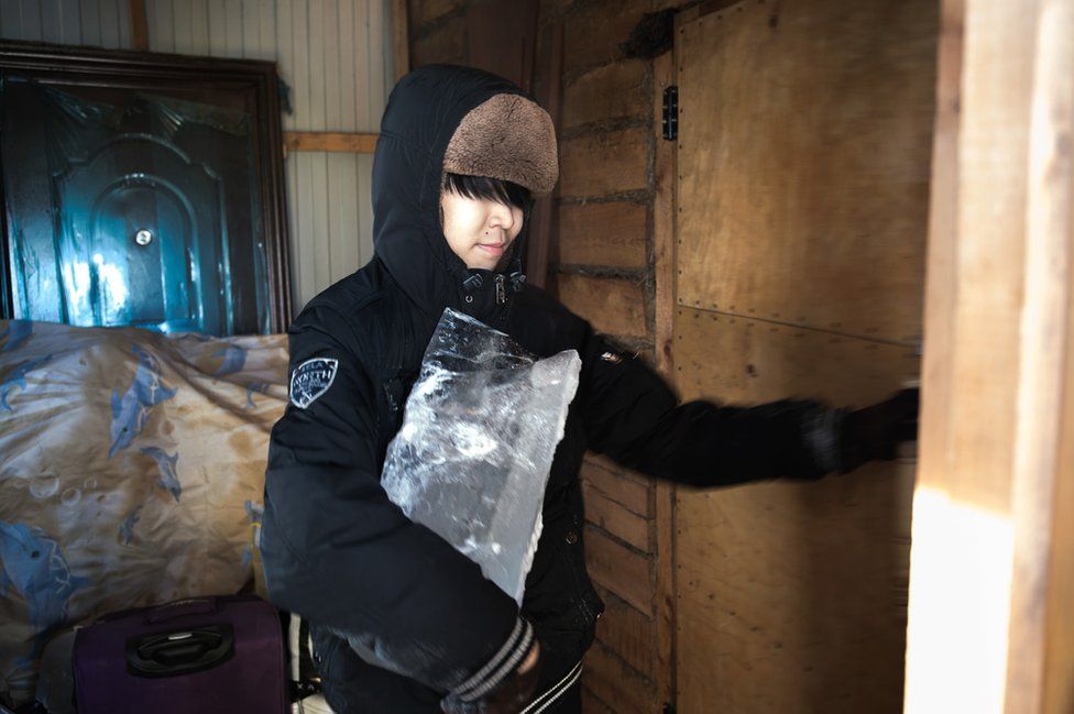 Ayal carries a block of ice that will be melted inside his house. Running water, which transits at very high temperatures to prevent the pipes from freezing, is not drinkable.